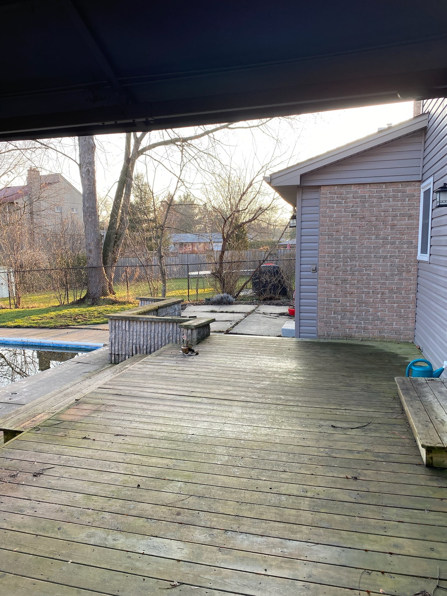 old concrete slab and wooden deck around pool