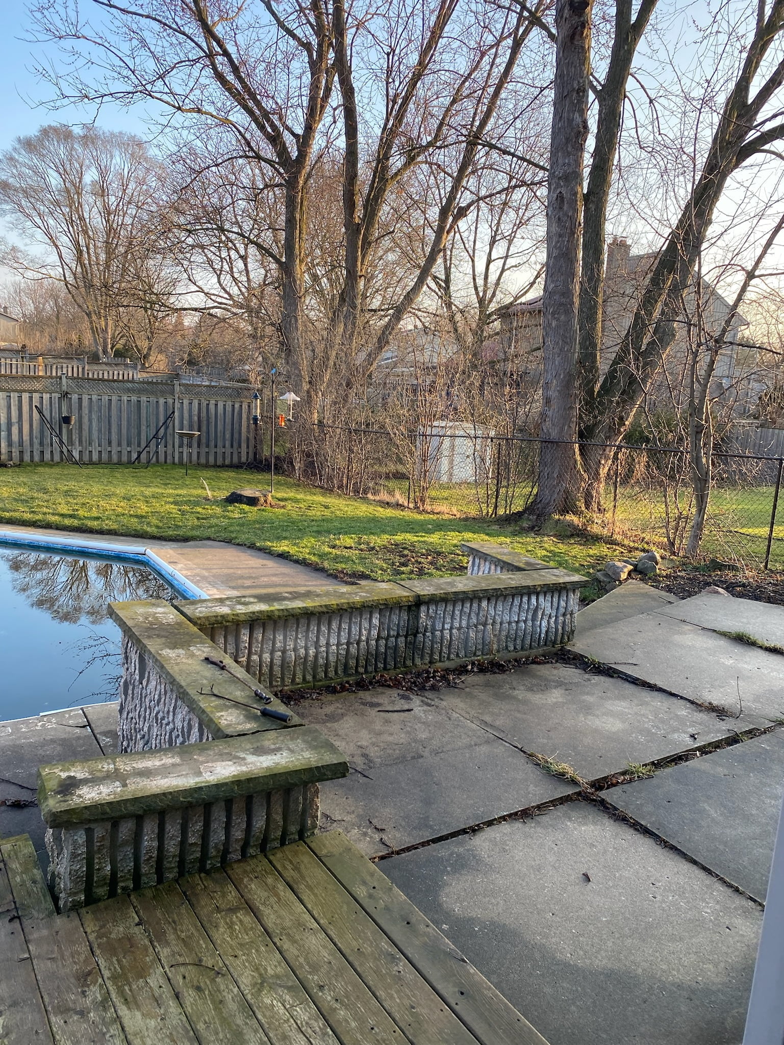 old concrete slab and wooden deck around pool