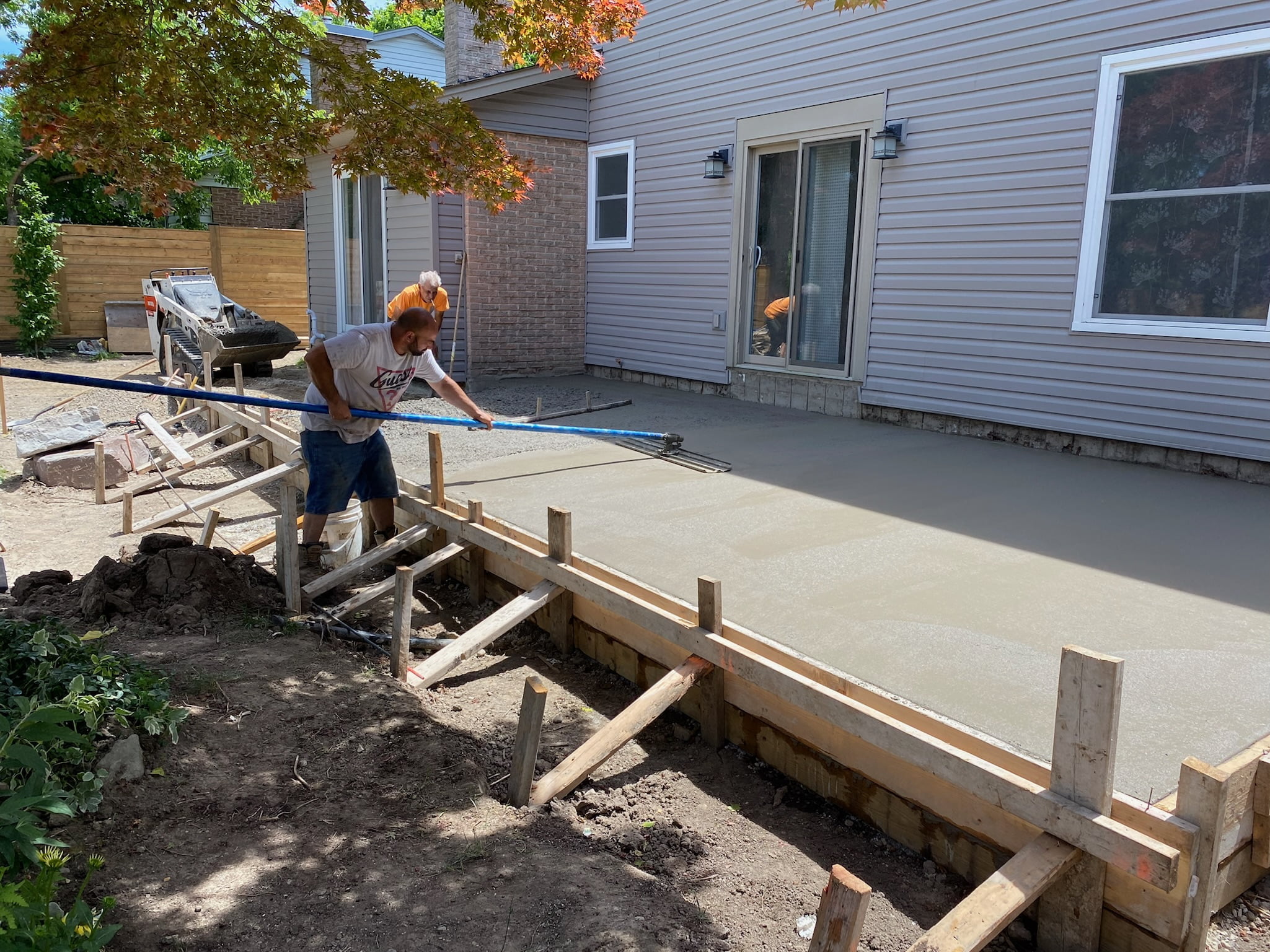 smoothing out freshly poured concrete patio