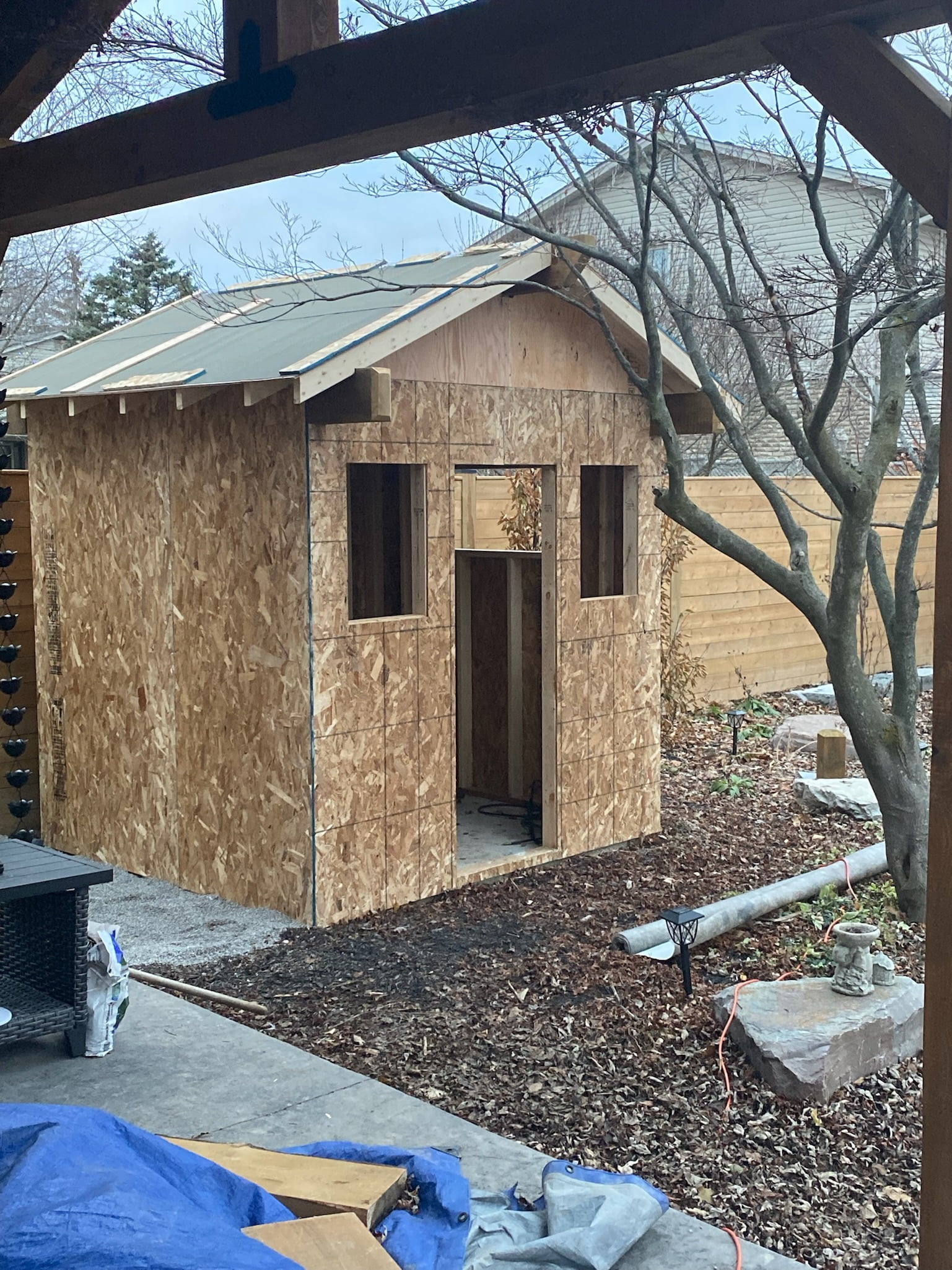 custom wooden pool shed with plywood added