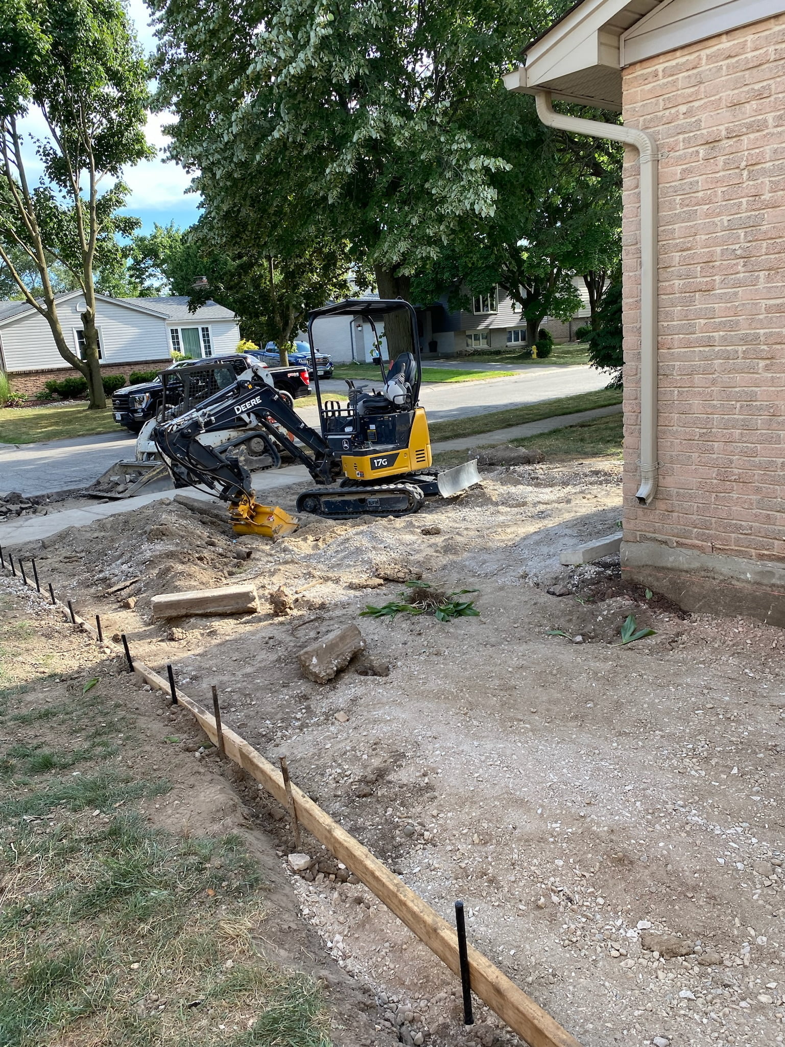 small digger prepping ground for new concrete driveway