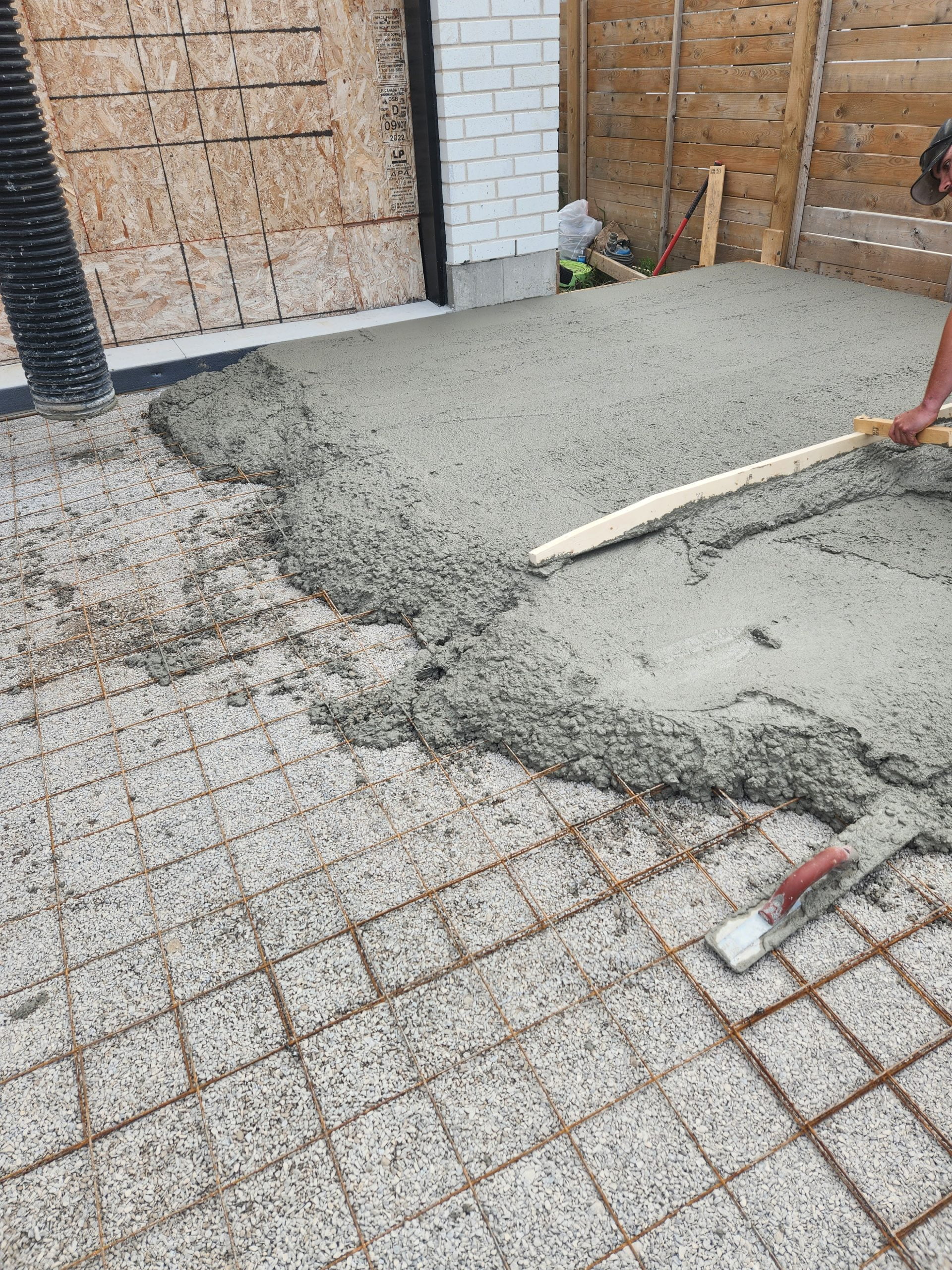 smoothing out freshly poured concrete for patio
