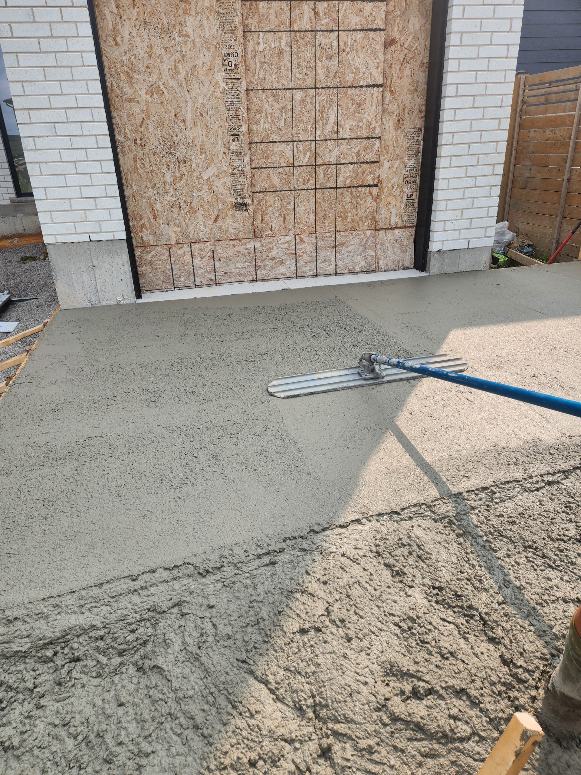 smoothing out freshly poured concrete for patio