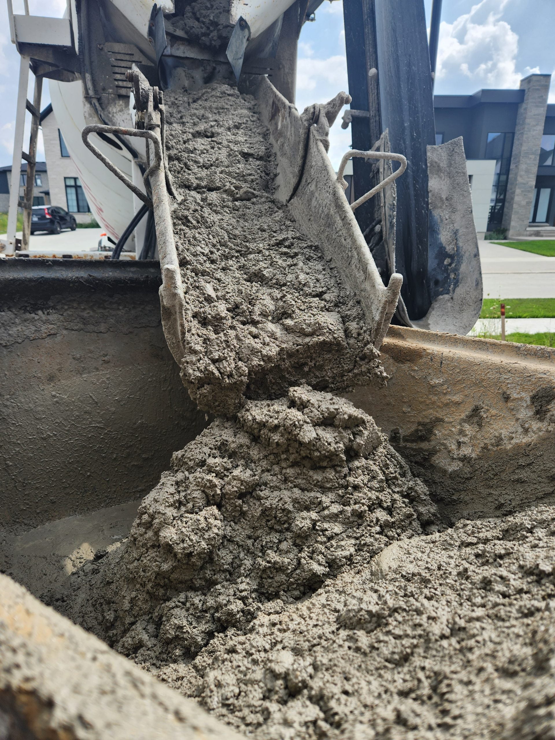concrete delivery from mixing truck into trailer to take it to backyard to grout bottom of pool and steel stairs