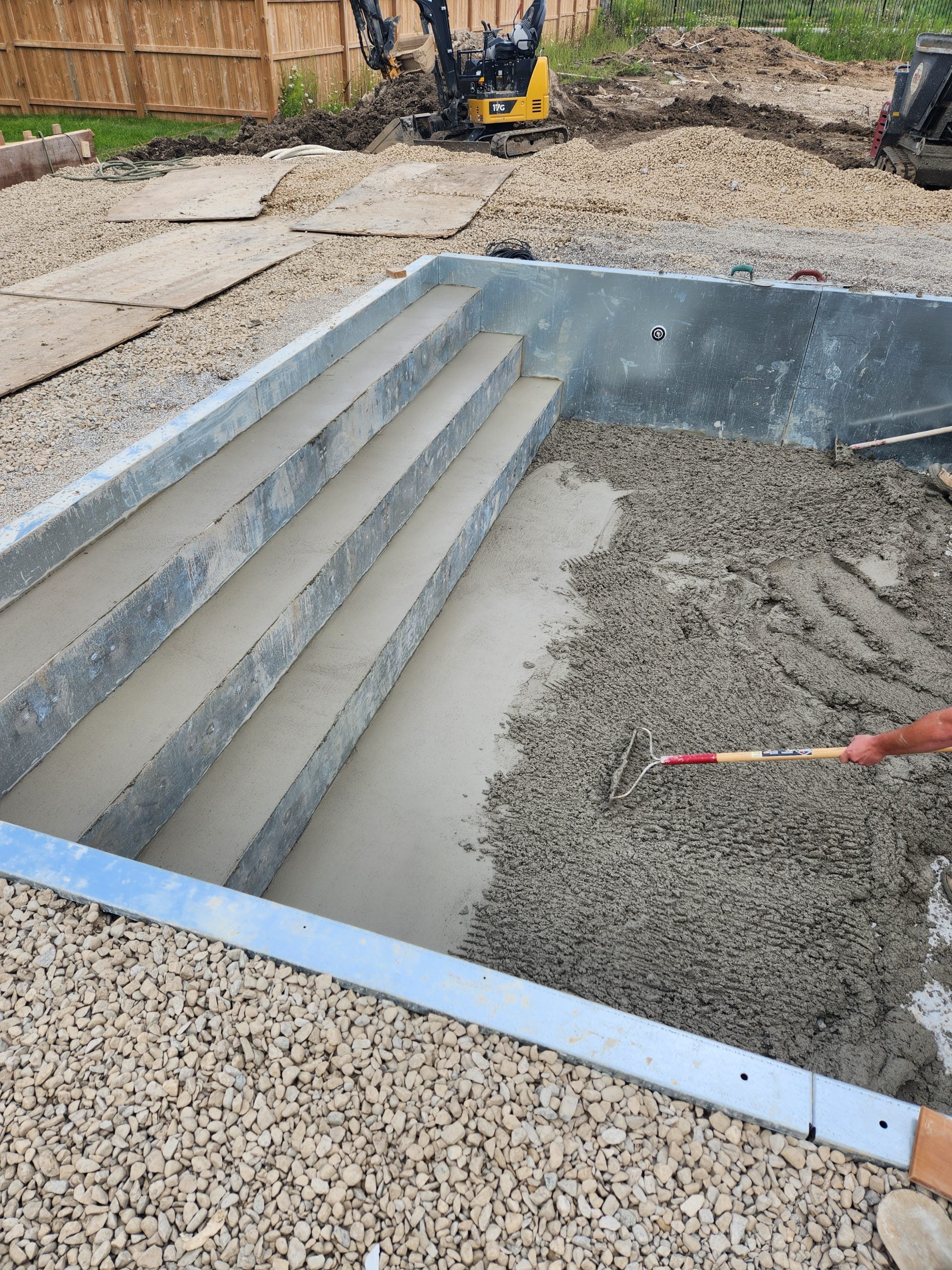 grouting bottom of inground pool and steel stairs with concrete