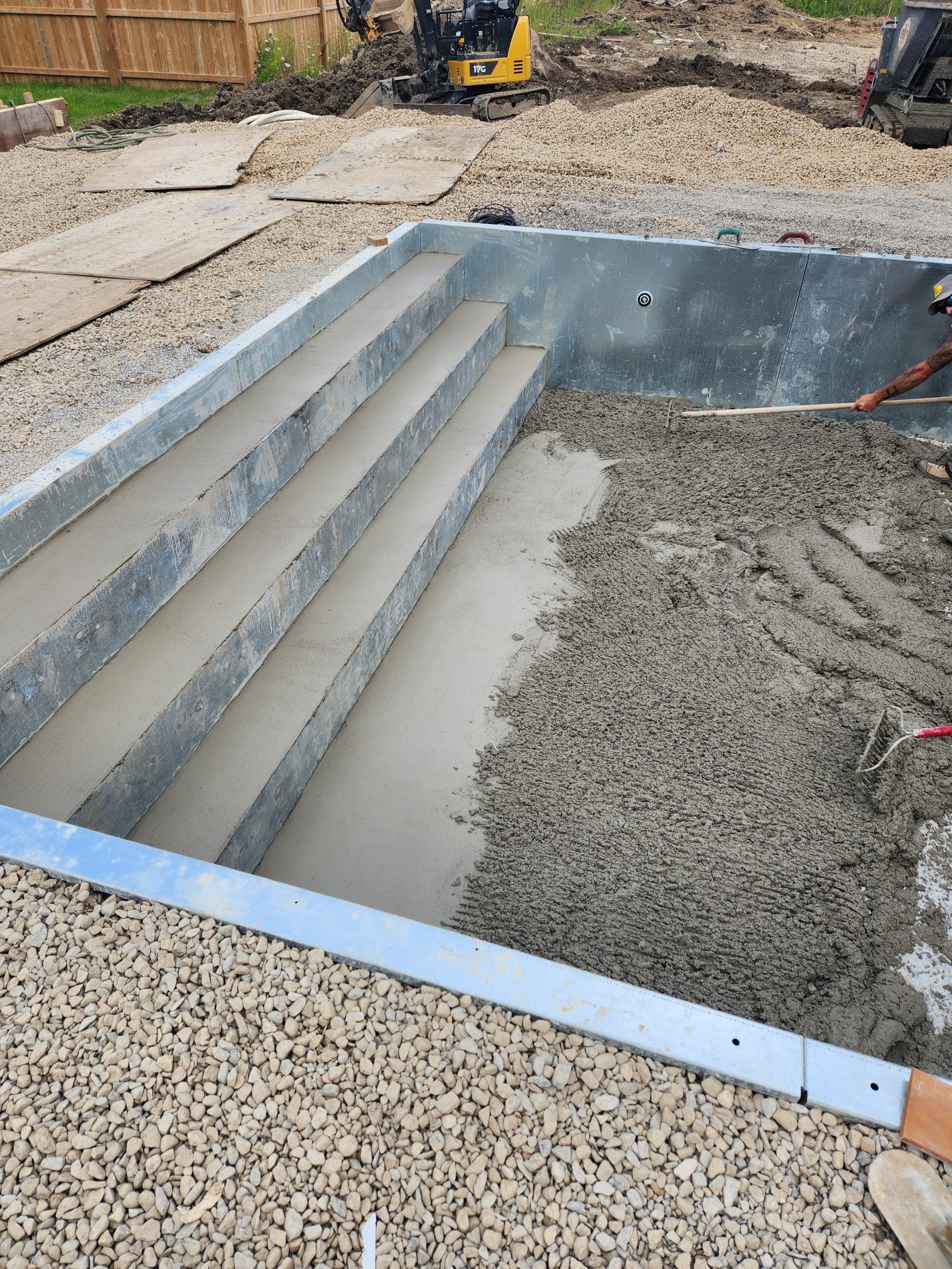 grouting bottom of inground pool and steel stairs with concrete