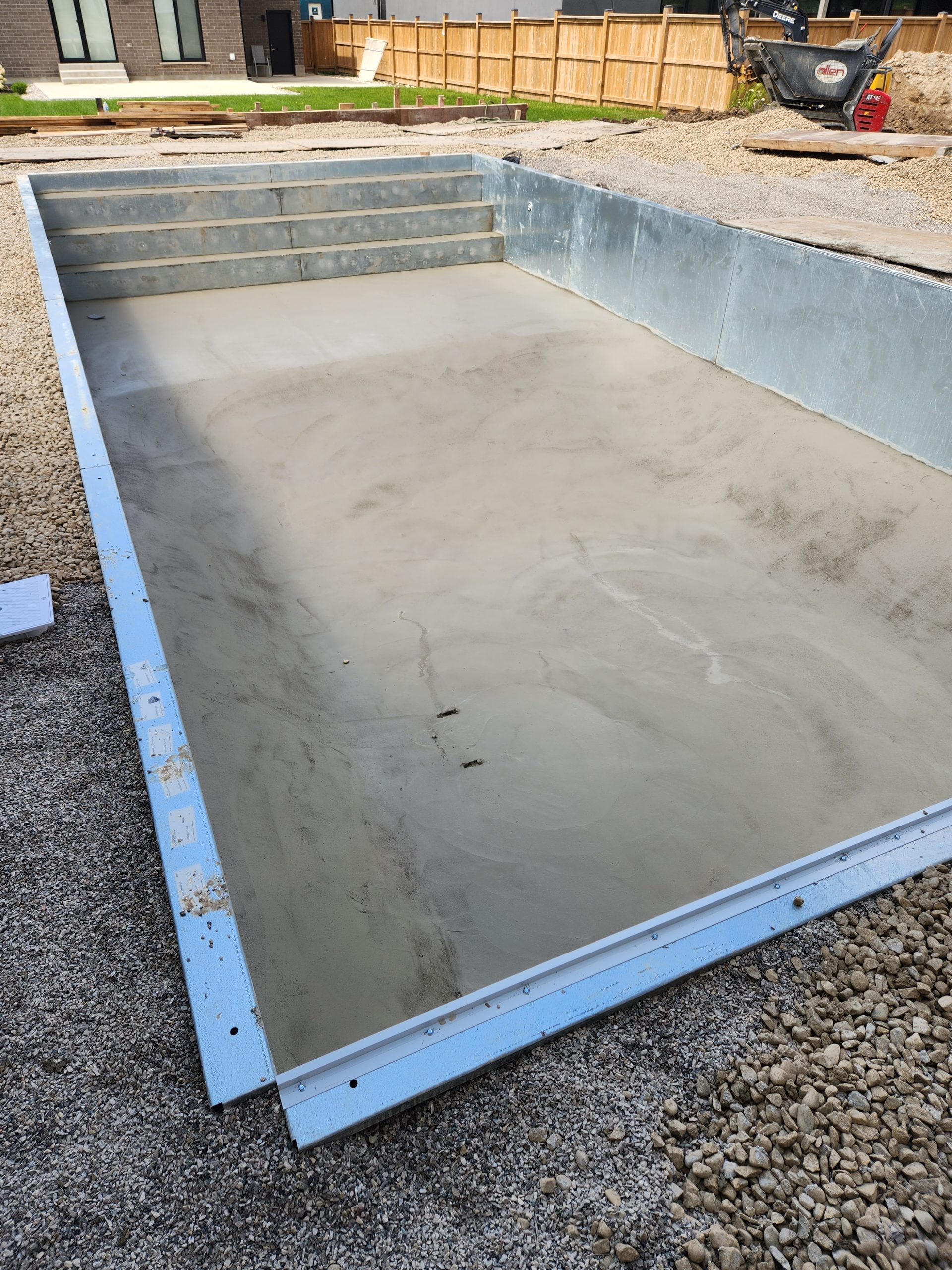 smoothed concrete on bottom of inground pool and steel stairs