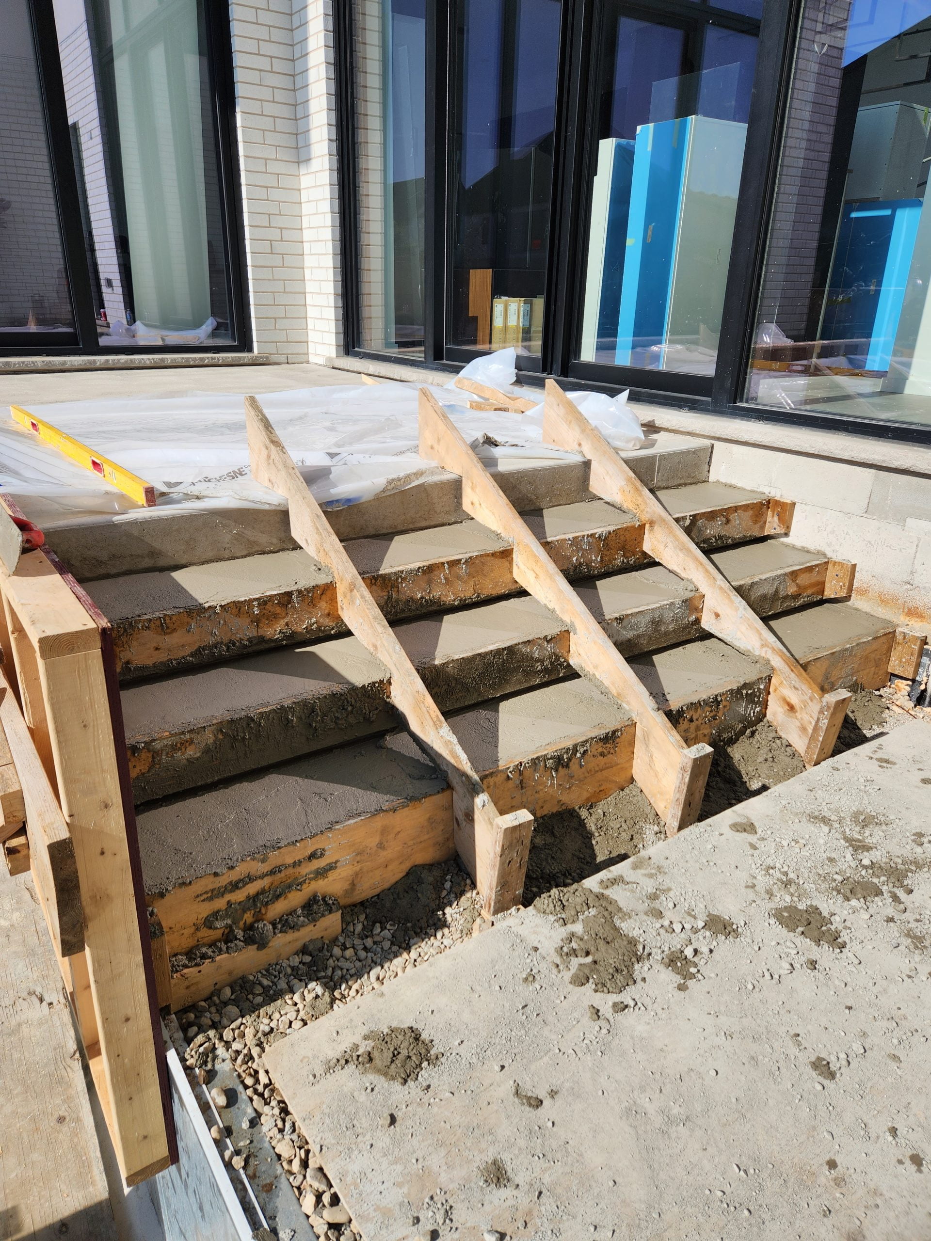 forming concrete stairs from upper level to lower level of concrete patio with wood