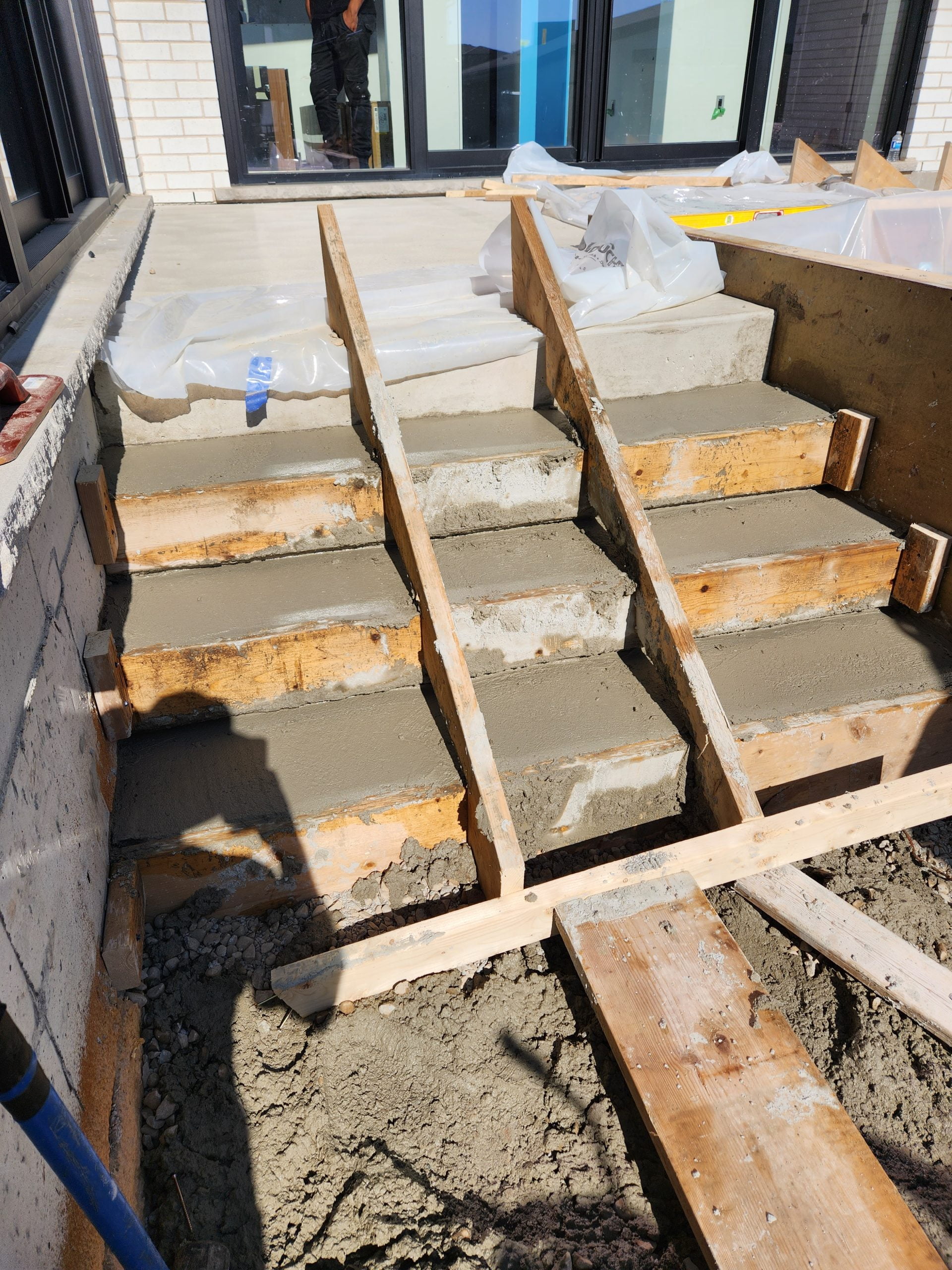 forming concrete stairs from upper level to lower level of concrete patio with wood