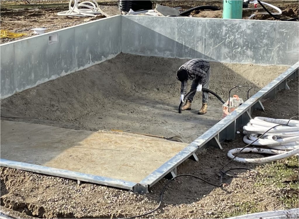 pool contractor preparing floor of new pool installation